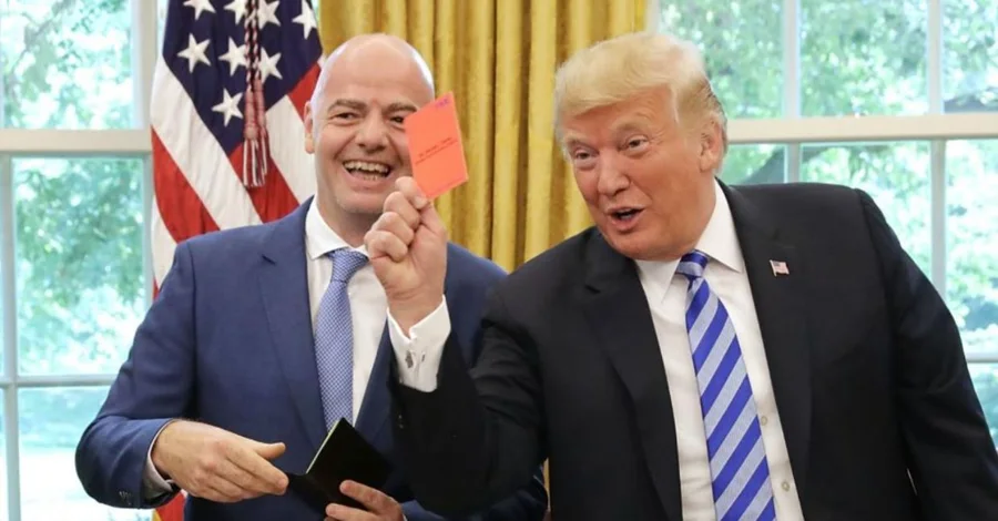 Donald Trump sostiene una tarjeta roja mientras sonríe junto al presidente de la FIFA, Gianni Infantino, durante una reunión en la Oficina Oval de la Casa Blanca